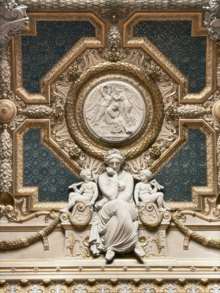Ornate gilded ceiling with a central sculpted relief