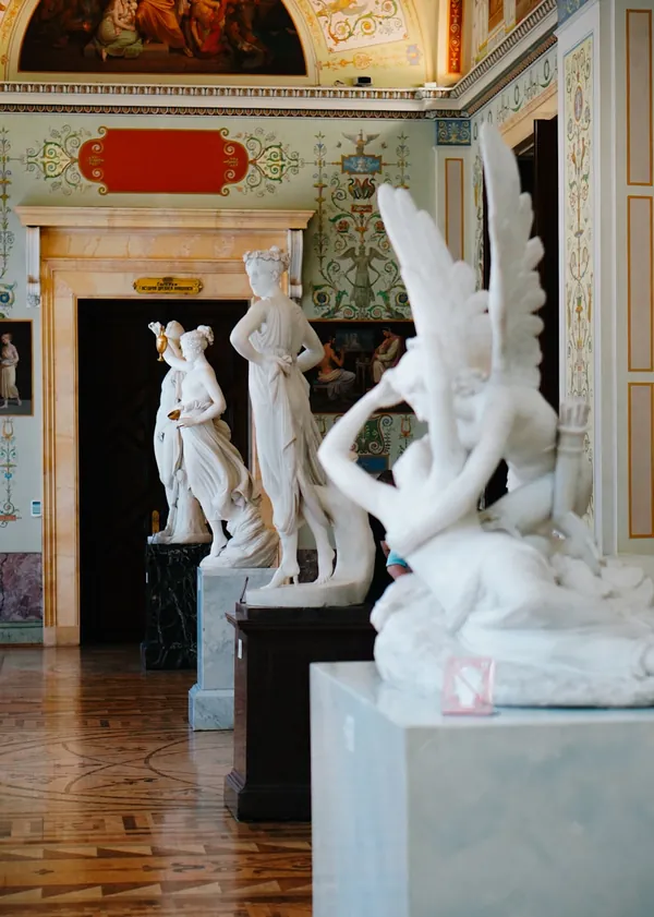 Marble statues displayed in an ornate gallery hall