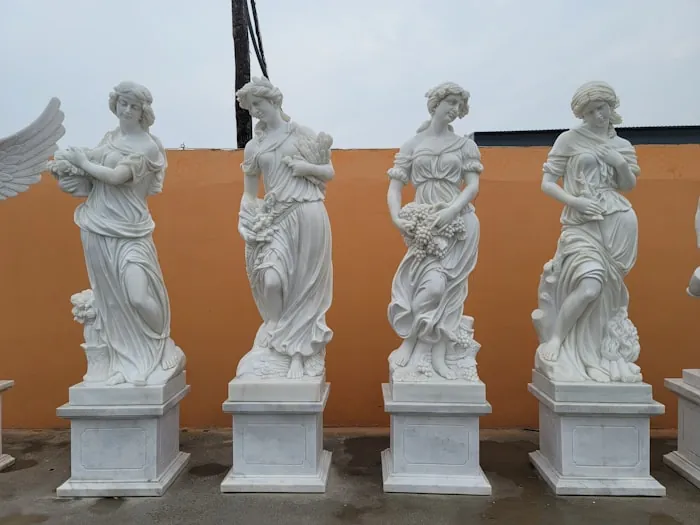 A row of white classical statues on pedestals